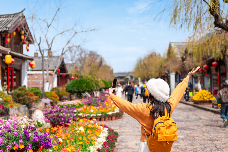 Mujer caminando por Yunnan cerca de casas